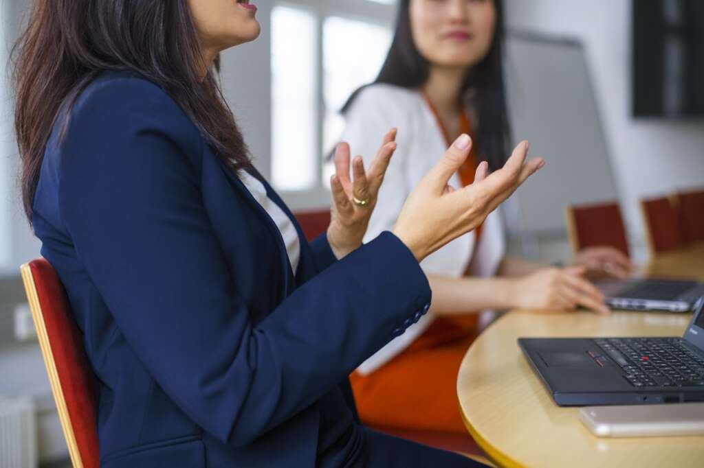 Businessnaiset keskustelevat kokoushuoneessa